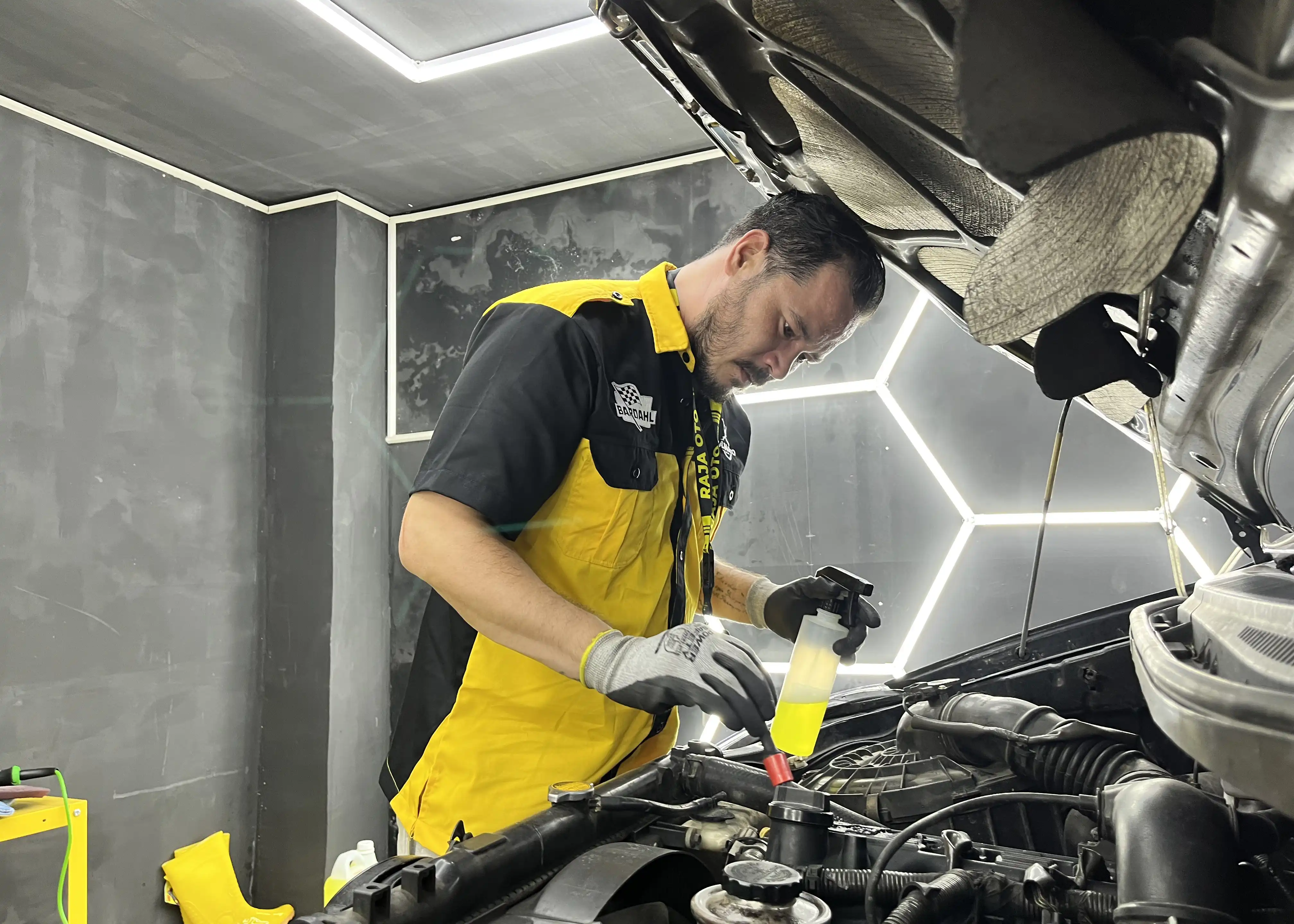 Teknisi Melakukan Pengecekan Cairan Mesin