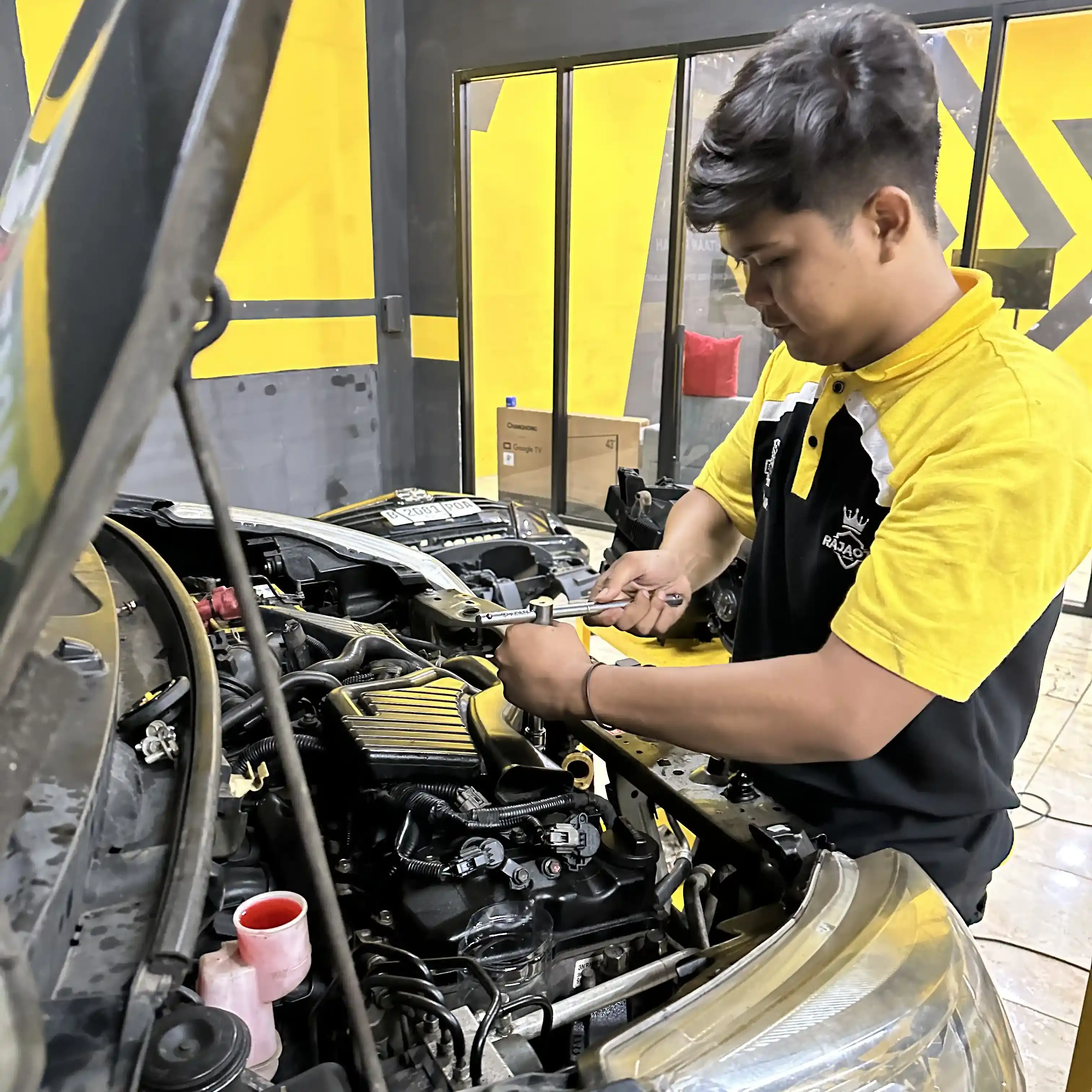 Teknisi Melakukan Perbaikan Mesin